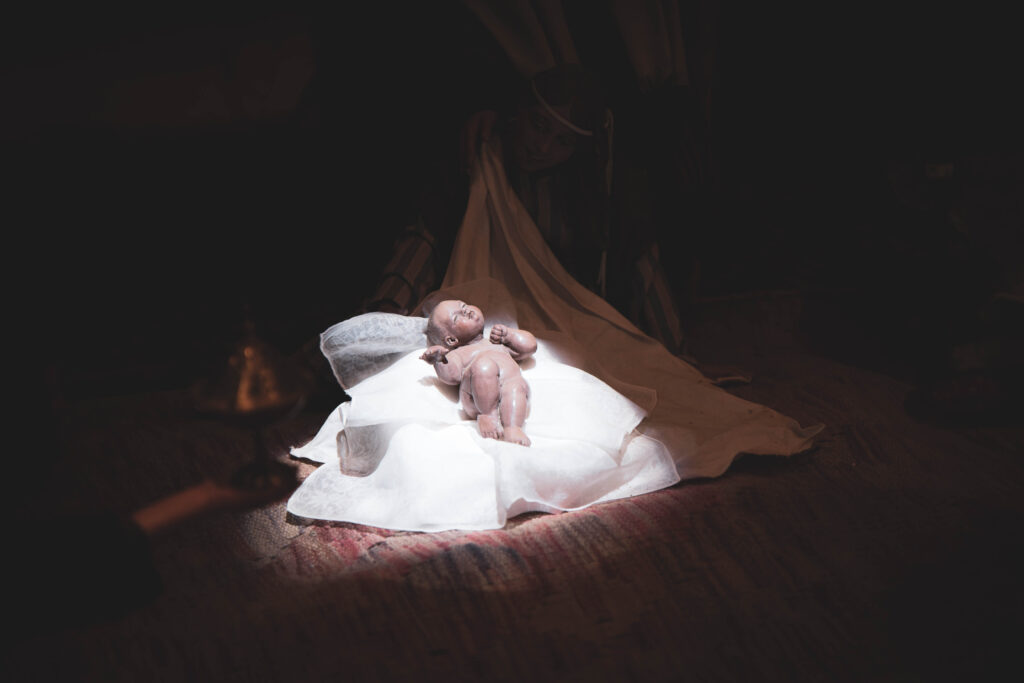 La Natività illuminata nel buio da una luce bianca intensa